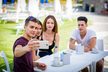 You smiling people making selfie sitting at table