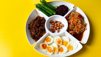 close up protein foods, eggs, meat, vegetables, rice berry, almond together on the white tray.