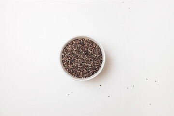Chia seeds in a bowl isolated on a white background.