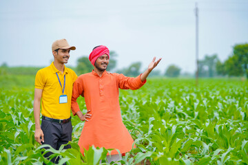 Indian agronomist or banker with farmer at green agriculture field.