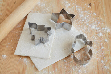 Preparation for baking Christmas cookies using metal molds in the form of a spruce, a snowman, a star