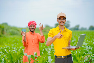Indian farmer with banker or agronomist at agriculture field.