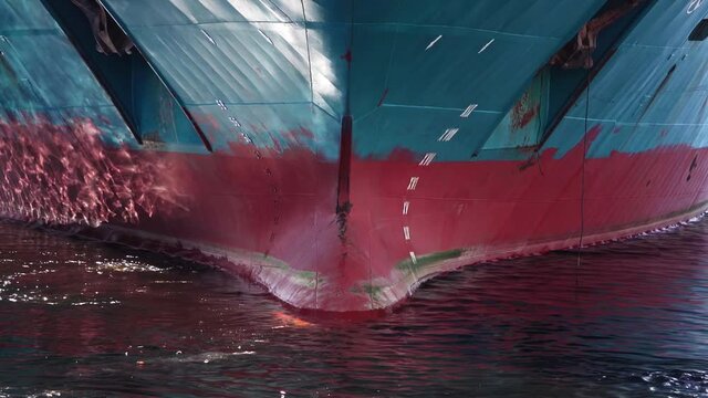 Bow of vessel. Ship sails back. Waterline of the vessel, two anchors. Close-up. Ship's keel