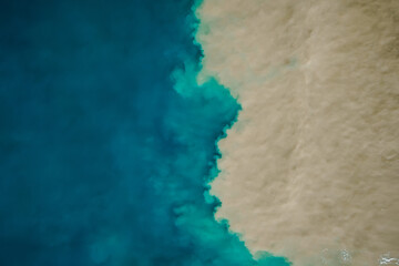 Aerial view of mixing blue and dirty water in sea.