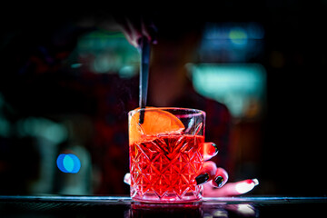woman hand bartender making negroni cocktail in bar