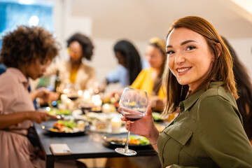 young red head woman looking at the camera and smiling, happiness and joyful gathering of friends - vegetarian dinner and people having fun concepts