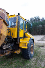The dump truck is three-axle. Close up.