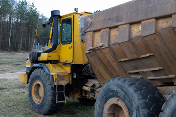 The dump truck is three-axle. Close up.