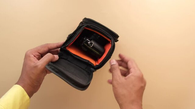 putting vintage camera in a small bag top view 