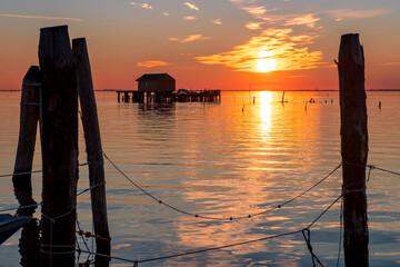 Sunset on the Venetian lagoon with the  fishermen's houses, Pellestrina island, Venetian lagoon, Italy