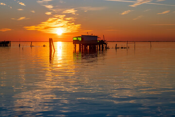 Sunset on the Venetian lagoon with the  fishermen's houses, Pellestrina island, Venetian lagoon, Italy