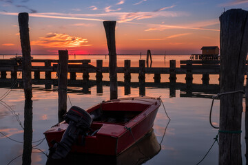 Sunset view of the Venetian lagoon with moored boat, Pellestrina island, Venetian lagoon, Italy