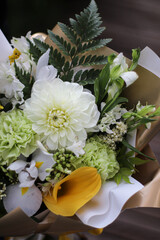 floral background of white dahlia, yellow calla and green carnations