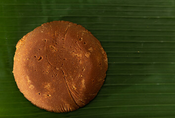 A large piece of Kithul Jaggery on a green banana leaf