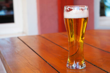 Glass of beer on wooden table. Rustic wood table, cold light beer