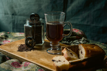 strand tea next to a chocolate chip cake. A background tea infuser.