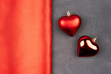 Red background border, with gray concrete wall with red ball hearts.