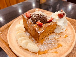 Honey toast with banana strawberry chocolate ice cream on a plate, ready to eat.