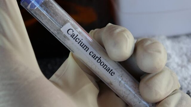 Calcium carbonate in test tube and black background