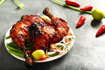 Homemade traditional Indian tandoori chicken  served in plate with fresh salads.  - obrazy, fototapety, plakaty
