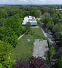 Football and basketball court in a city park in Mortsel fort 4 near Antwerp Concrete sports by swimming pool building with solar panels on roof. Drone aerial view from above