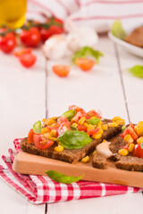 Rye bread withsweet corn, basil and tomato.