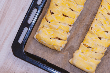 Fruit homemade pieon a baking sheet. Baked braided pigtails with fruits. pigtail of dough.