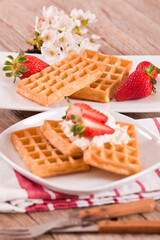 Waffles with strawberries and whipped cream.