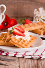 Waffles with strawberries and whipped cream.