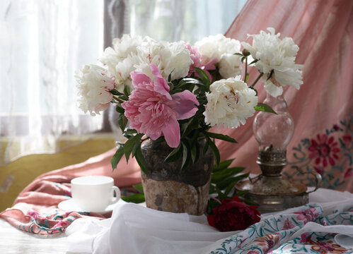 Still life with white and pink peonies in a old ceramic vase