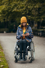 Woman with disability using a smartphone while out in the city park