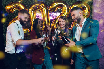 Happy group of friends celebrate New Year's Eve in a club