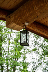 A vertical shot of a vintage lamp hanging on a wooden roof