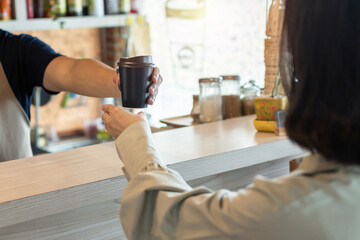 waitress staff serving hot coffee cup for female customer in modern cafe coffee shop, food...