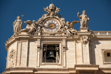 Vatican clock with sculptures on the roof of Basilica of Saint Peter and old bell, Vatican city