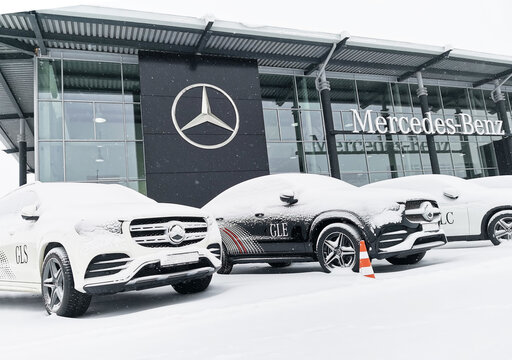 Mercedes cars stand under the snow at the will of the car showroom