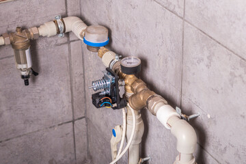 there is a pipe with water on the tiled wall. a water meter is also installed. automation is...