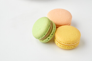Colored pastries lie on a white background. Macaroons
