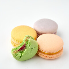 Colored pastries lie on a white background. Macaroons
