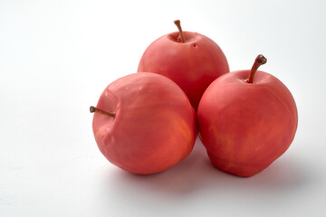 cake in the form of a red apple lies on a white background
