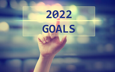 2022 Goals concept with hand pressing a button on blurred abstract background