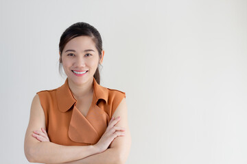 Smart Asian beautiful wear sleeveless brown suit are cross one's arm with smiling and confident and...