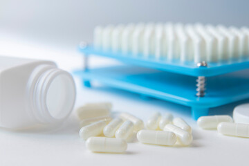 White pill capsules lay on floor  near white bottom