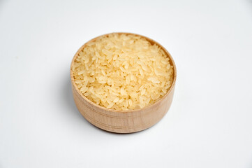 white rice grains in a wooden bowl