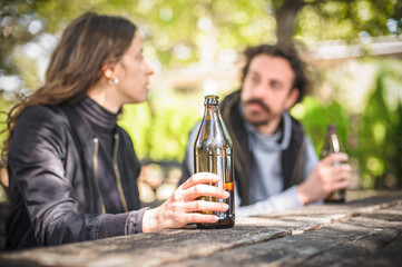 Couple in quarrel, boyfriend and girlfriend drinks beer from bottle