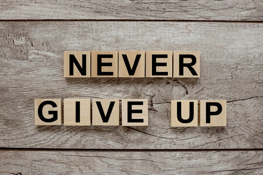never give up. text on wood blocks on wood table