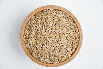 sunflower seeds in a wooden bowl on a white background