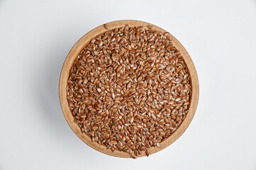 flax grain in a wooden bowl on a white background