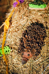 Recycling: a hedgehog and a mushroom made of plastic bottles in a garden. Hedgehog from cones with their own hands.