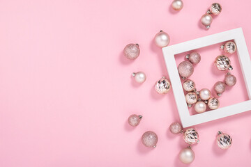 Square podium and pink decorative balls on a pink background. Top view, flat lay.